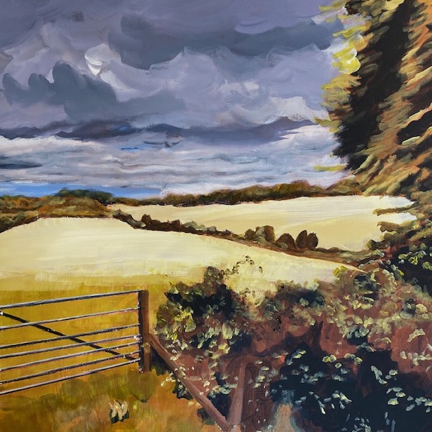 a view over sun-bleached hills and a stormy sky through a gateway